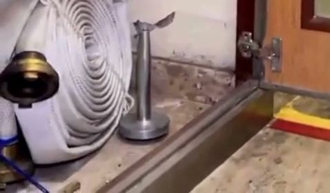 Abrigo de hidrante aberto, com a mangueira enrolada e o esguicho no suporte