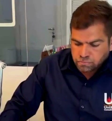 Engenheiro da União Consultoria, de uniforme escuro, debruçado sobre a mesa do escritório